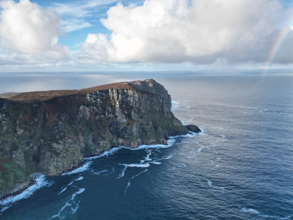 a cliff with a rainbow