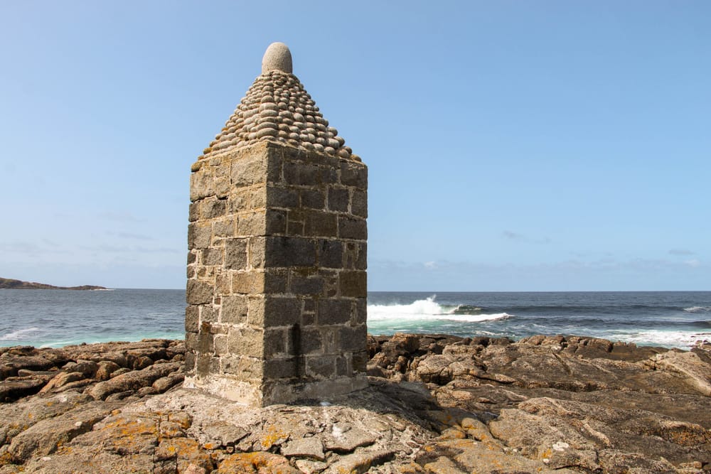 a stone tower on a rocky beach