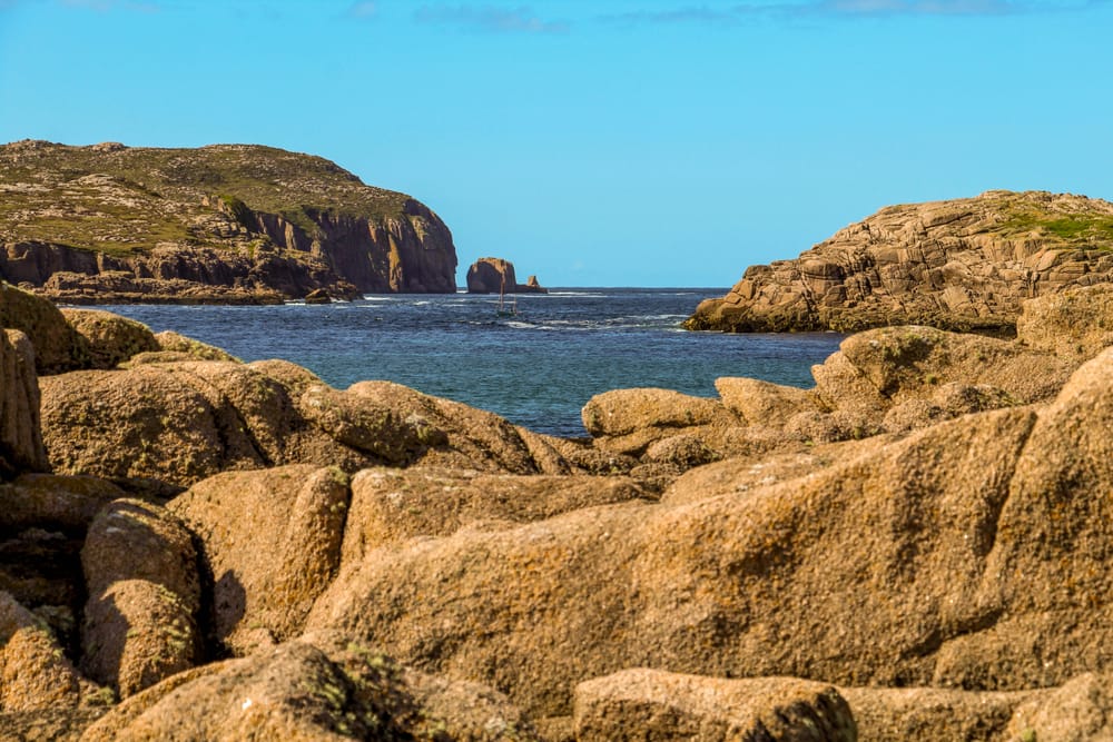 a rocky shoreline with a body of water in the background